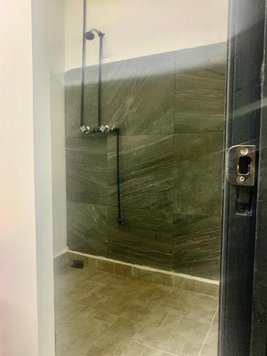 y baño con ducha y puerta de cristal. en Hostal YOA 101, en Ciudad de México