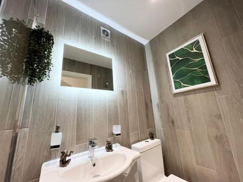a bathroom with a sink and a toilet and a mirror at Beautiful High-Spec City Centre Flat - Next to Tube & Balcony in London