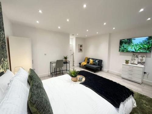 um quarto com uma cama grande e uma televisão na parede em Beautiful High-Spec City Centre Flat - Next to Tube & Balcony em Londres