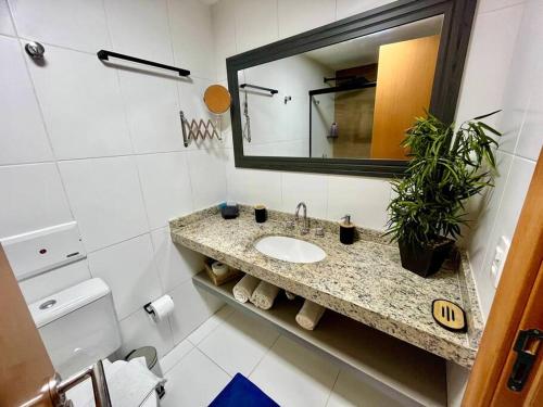 ein Bad mit einem Waschbecken und einem Spiegel in der Unterkunft Studio Acqua - estilo no melhor bairro da cidade in Niterói