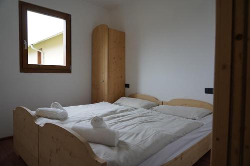 a bedroom with a bed with towels on it at Hotel Residence Bellavista - Camping Polsa in Brentonico
