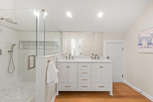 a white bathroom with a sink and a shower at 770 Spinnaker Beach House in Seabrook Island