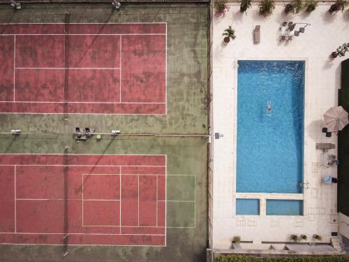 an overhead view of a tennis court and a swimming pool at Résidences Les Hauts de l'Indenié in Abidjan