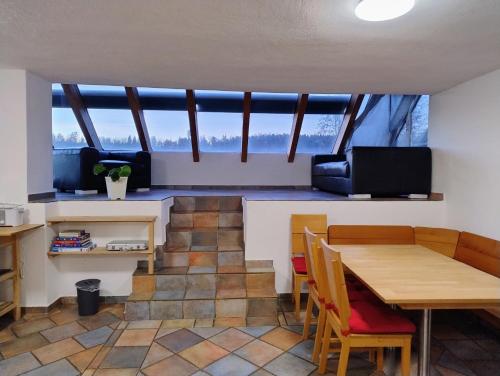 ein Wohnzimmer mit einem Tisch und Stühlen sowie einem großen Fenster in der Unterkunft Ferienwohnung am Egelsee 