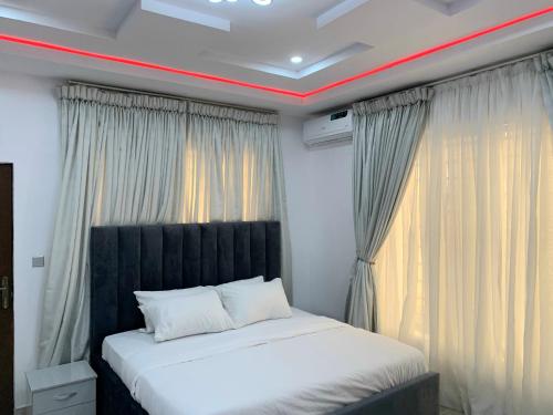 a bed with a black headboard in a room at The Residenze Adeniyi Jone Ikeja in Lagos