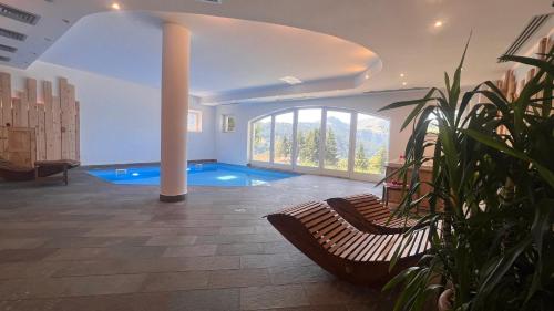 a large room with a swimming pool and a bench at Hotel Residence Bellavista - Camping Polsa in Brentonico