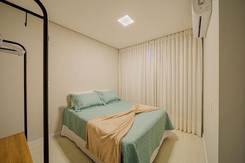Habitación pequeña con cama y ventana en MORSE 1007 Charme e elegância para sua estadia, en Joinville