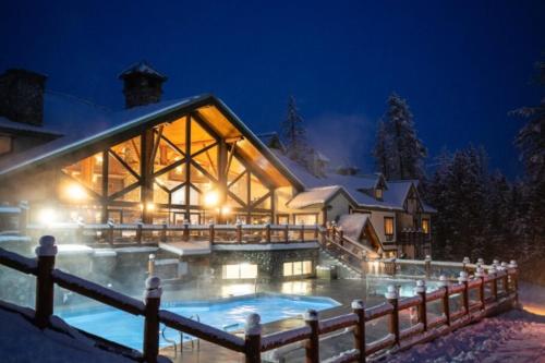 ein Haus mit Pool im Schnee in der Unterkunft Lizard Creek Lodge in Fernie
