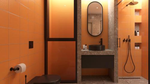 an orange bathroom with a sink and a mirror at Sokaki Alley Houses Upper floor in Kardamaina