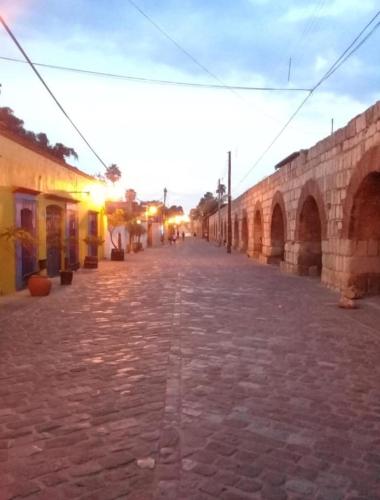 an empty street with an old brick road at Casa los Arcos Oaxaca in Oaxaca City