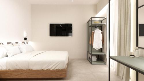 a bedroom with a bed and a tv on a wall at Sokaki Alley Houses Upper floor in Kardamaina