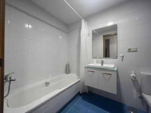 ein weißes Badezimmer mit einer Badewanne, einem Waschbecken und einer Badewanne in der Unterkunft Öspede Sisarga Chica Malpica de Bergantiños-Costa da Morte in Malpica