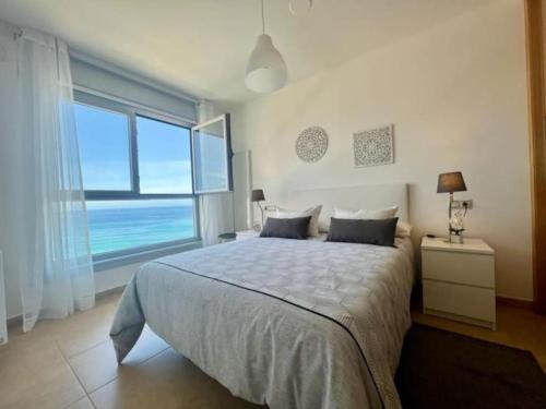 ein Schlafzimmer mit einem großen Bett und einem großen Fenster in der Unterkunft Öspede Sisarga Chica Malpica de Bergantiños-Costa da Morte in Malpica
