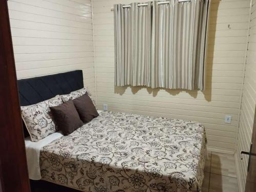 a bedroom with a bed and a window at Pousada Vó Irene in Urubici