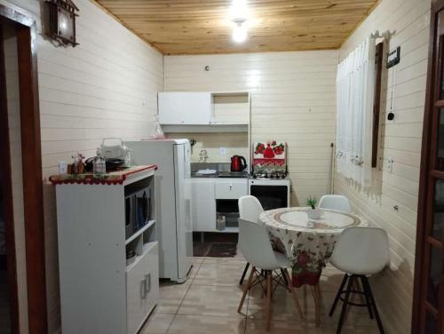 a kitchen with a table and chairs in a room at Pousada Vó Irene in Urubici