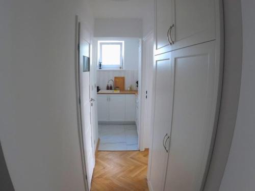 ワルシャワにあるŚliska Central Location, high standardの白いキッチン(シンク付)、白いドア
