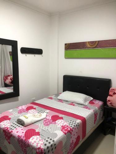 a bedroom with a bed and a mirror at HOTEL LONDRES PLAZA in Pitalito