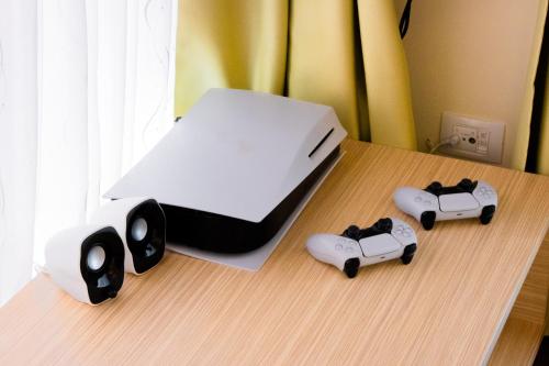 a bed with two controllers on a wooden table at Apartma Bazilika in Topolšica