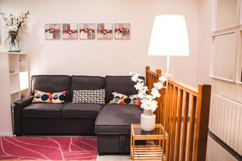 - un salon avec un canapé noir et une lampe dans l'établissement Charming souplex in Paris, à Paris
