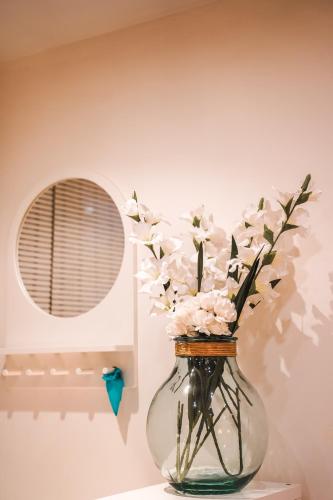 un vase en verre avec des fleurs sur une table dans l'établissement Charming souplex in Paris, à Paris