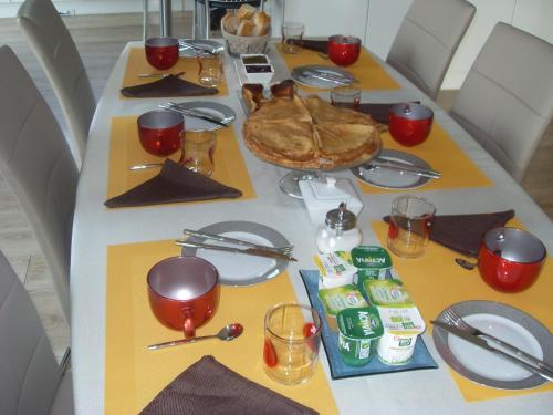 a long table with a white and yellow table cloth at Chambre d'hôtes Les Bruyères in Bruc-sur-Aff