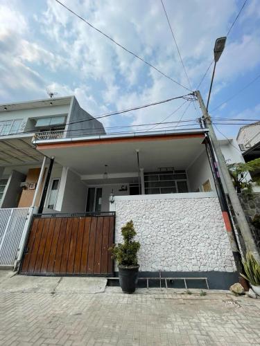 a house with a wooden gate and a fence at Clamitan House in Padalarang