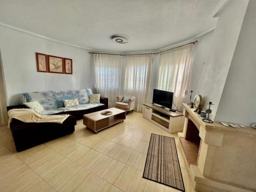uma sala de estar com um sofá e uma televisão em Villa Calma em Ciudad Quesada