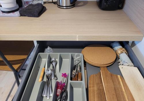 a drawer with utensils in it under a counter at Les 3 Bulles in Gueux