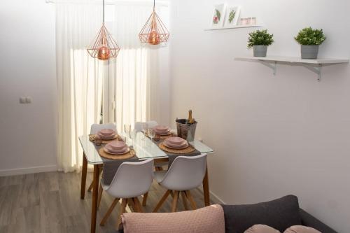 a dining room with a table and four chairs at Casita tentación con jacuzzi Privado in Málaga
