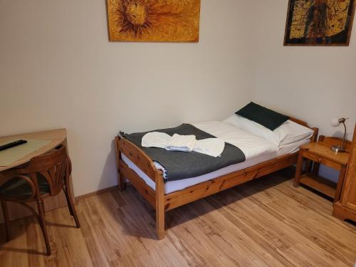a small bedroom with a bed and a desk at Penzion Klopacka in Špania Dolina