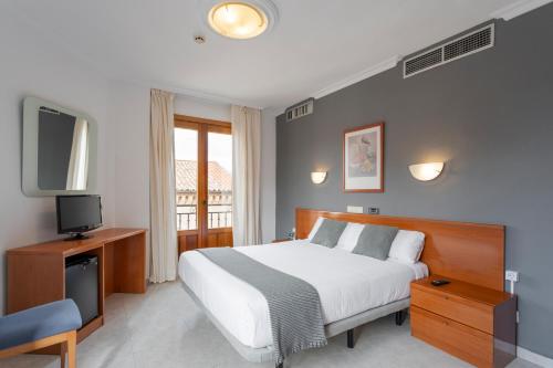 sypialnia z łóżkiem i telewizorem oraz łóżko sidx sidx sidx w obiekcie Hotel Alda Ciudad de Toro w mieście Toro