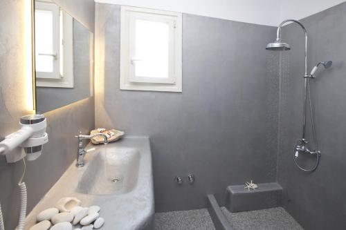a bathroom with a sink and a shower at Naxos Euphoria Suites in Stelida