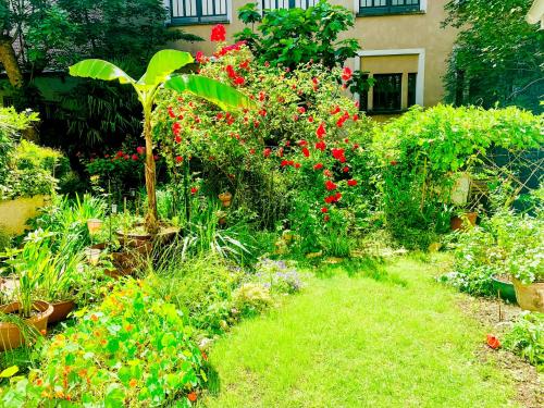 un jardin avec des fleurs et des plantes devant un bâtiment dans l'établissement ღ Le Jardin Parisien Calme avec Terrasse et Wifi ღ, à Paris