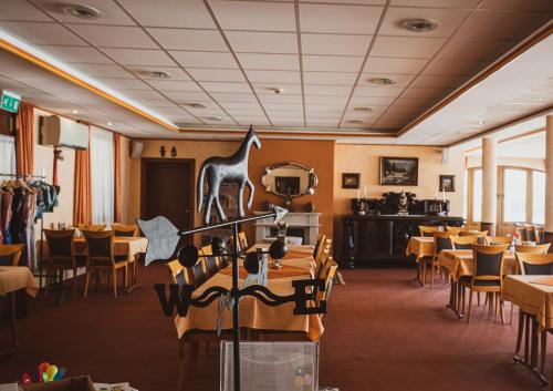 a restaurant with tables and chairs and a giraffe on the wall at Hétkúti Wellness Hotel in Mór