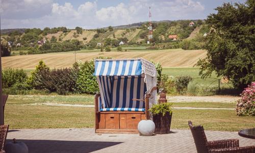 a chair with a blue and white striped towel on a patio at Hétkúti Wellness Hotel in Mór
