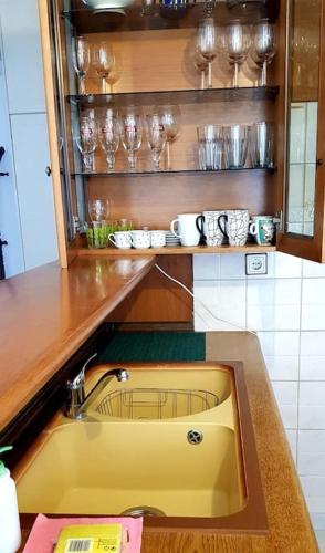 a kitchen with a sink and glasses on a shelf at Parga Center Apartment in Parga
