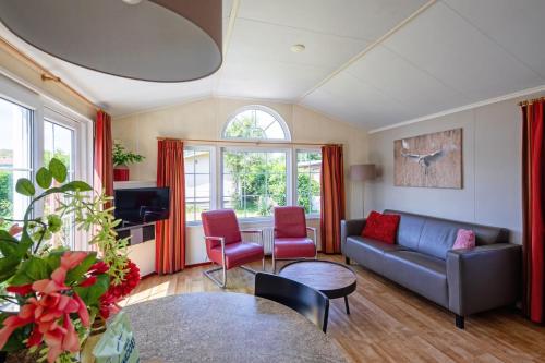 Chalet de Slufter Texel في دي كوكْسدوربْ: غرفة معيشة مع أريكة وطاولة