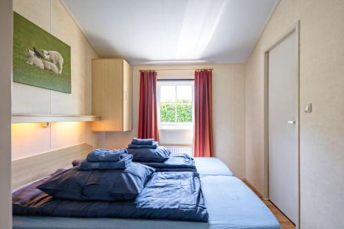 a bedroom with two beds in a room with a window at Chalet de Slufter Texel in De Cocksdorp