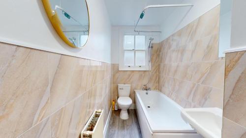 a bathroom with a tub and a toilet and a sink at My Lovely Clapham Flat in London