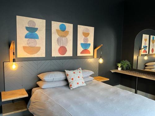 ein Schlafzimmer mit einem Bett mit vier Bildern an der Wand in der Unterkunft Beachouse@Stilbaai in Stilbaai