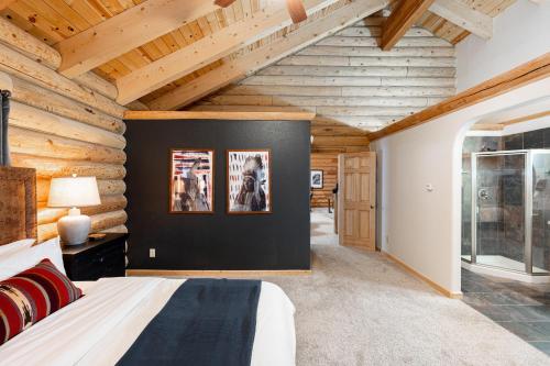 a bedroom with wooden walls and a bed in a room at Iconic Log Cabin Escape - Idaho Springs - Hot Tub in Idaho Springs