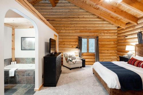 a log cabin bedroom with a bed and a tub at Iconic Log Cabin Escape - Idaho Springs - Hot Tub in Idaho Springs