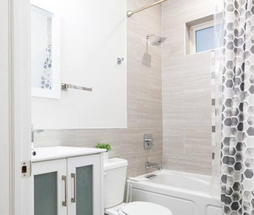 uma casa de banho com um WC, uma banheira e um lavatório. em City Explorer's Dream - 3BR Gem with WiFi+Laundry em Filadélfia