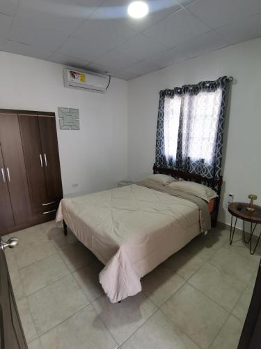 a bedroom with a bed and a window and a table at Apartamento full en David, Chiriquí. 