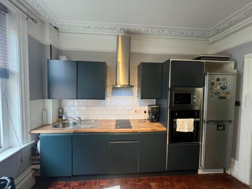 a kitchen with blue cabinets and a refrigerator at Central London Apartment (1) in London