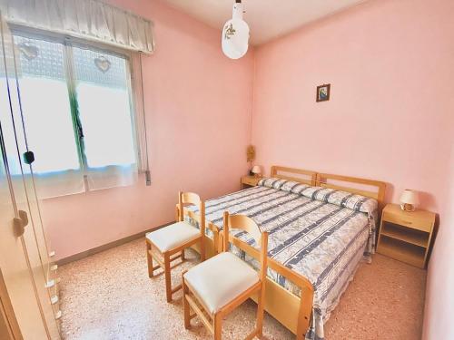 1 dormitorio con 1 cama, 2 sillas y ventana en Appartamenti FRONTESPIAGGIA CERVIA, en Cervia