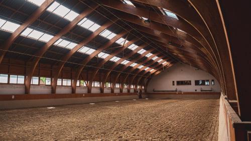 a large barn with a large ceiling with windows at Hétkúti Wellness Hotel in Mór