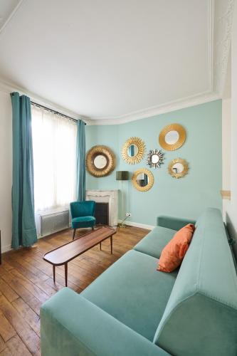 - un salon avec un canapé bleu et des miroirs dans l'établissement Très cosy 45m2, proche du parc des expositions, à Paris