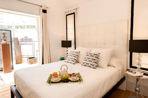 Un dormitorio con una cama con una bandeja de comida. en Bungalow Melocotones Maspalomas Golf, en Maspalomas