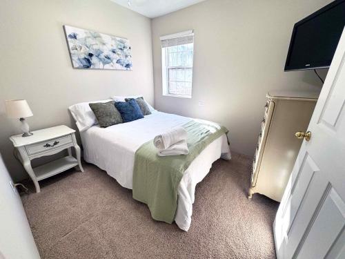 um pequeno quarto com uma cama e uma televisão em 415 Holland Springs em Kennesaw